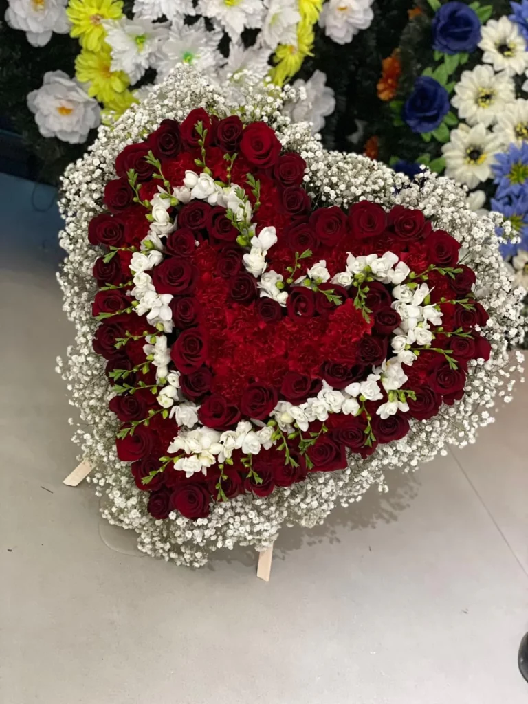 Composizione floreale funebre con rose rosse e bianche